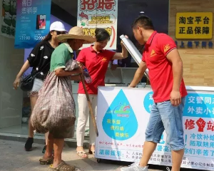一位老人经过志愿者的引领免费拿到一瓶水.png